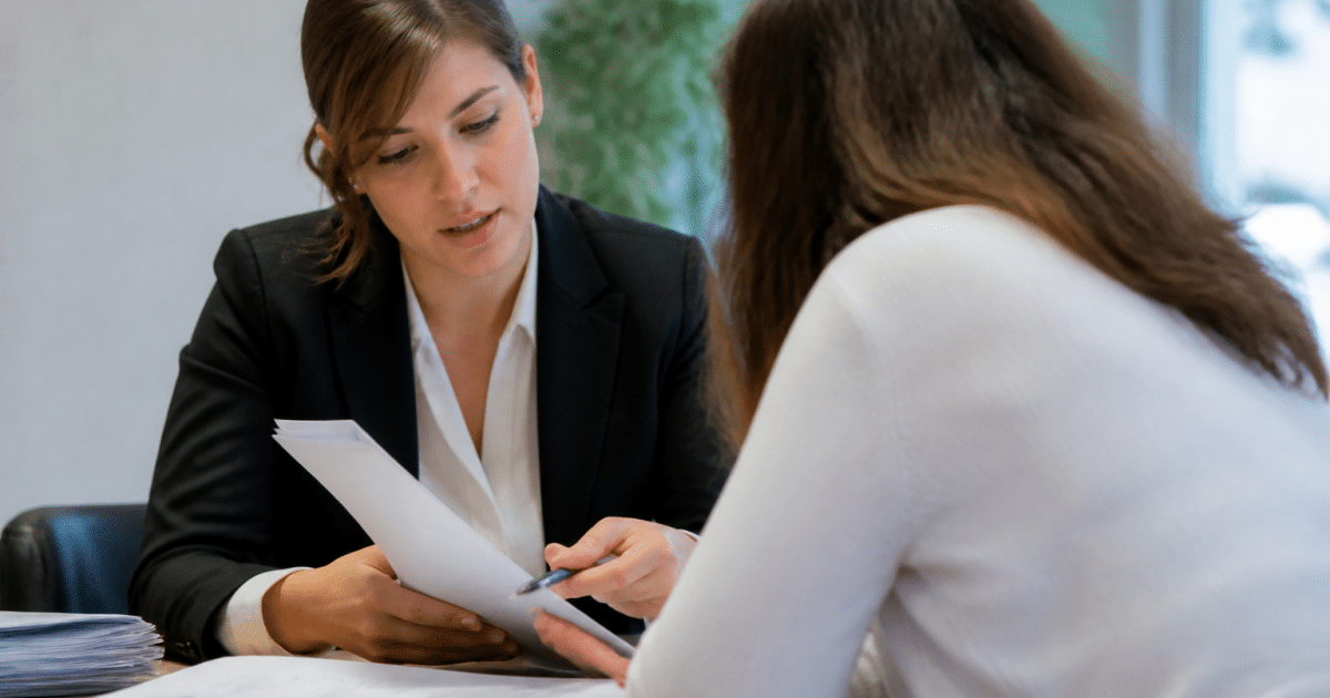 Conseiller bancaire presentant contrats pret a client assis